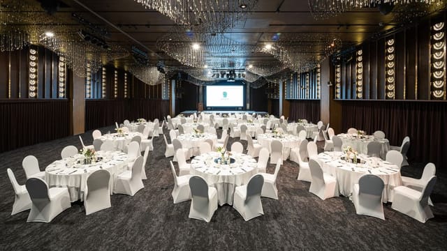 Elegant boardroom setup with round tables for conferences and gala dinners.