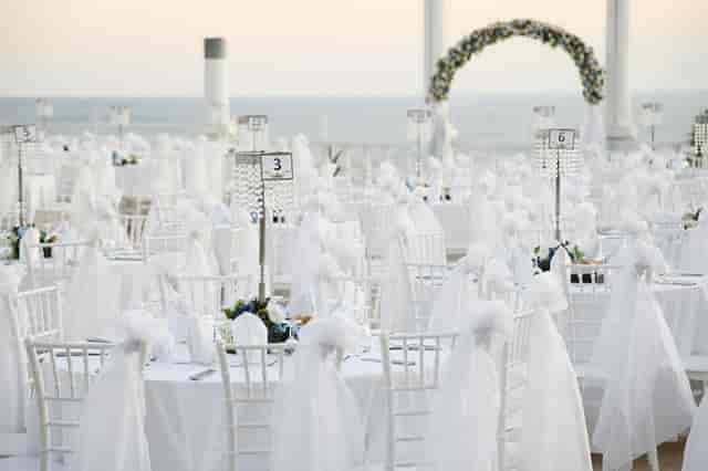 Outdoor wedding chapel in Adonis Hall with floral arch and ocean backdrop.