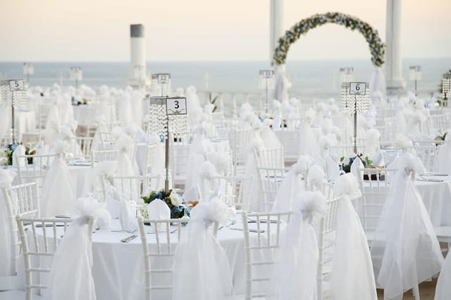 Outdoor wedding chapel in Adonis Hall with floral arch and ocean backdrop.