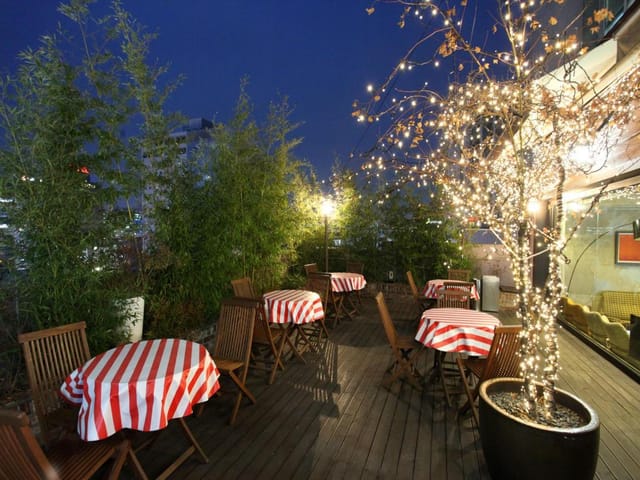 Rooftop terrace at Skypark Hotel with striped tables for intimate evening events.