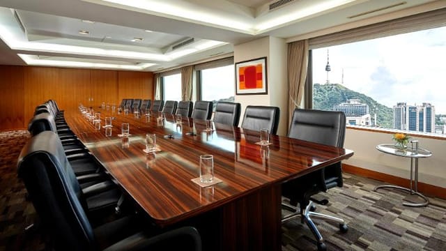 Modern conference room with wooden table and leather chairs for professional meetings.