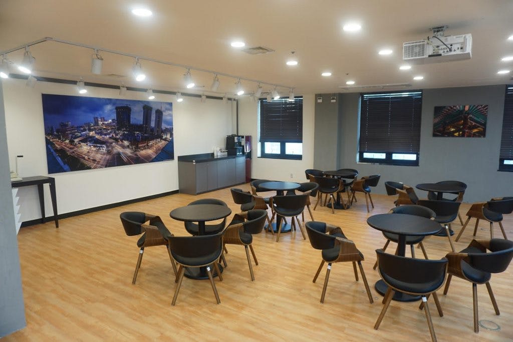 Versatile conference room with round tables, ideal for networking and workshops.