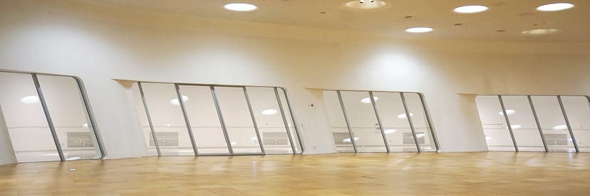 Modern exhibition hall with large windows, ideal for corporate events and gatherings.