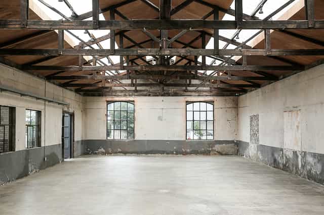 Spacious industrial venue with high ceilings for creative events and corporate gatherings.