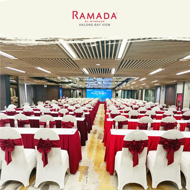 Ramada By Wyndham conference room with red tablecloths, ideal for seminars and events.