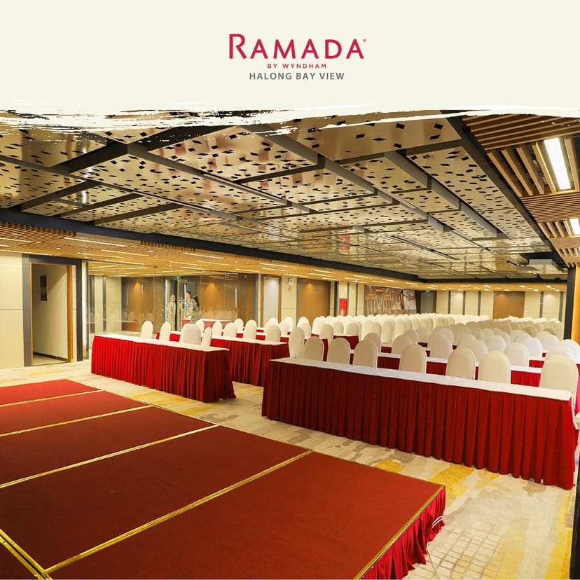 Ramada By Wyndham meeting room with red tables and white chairs, perfect for conferences.