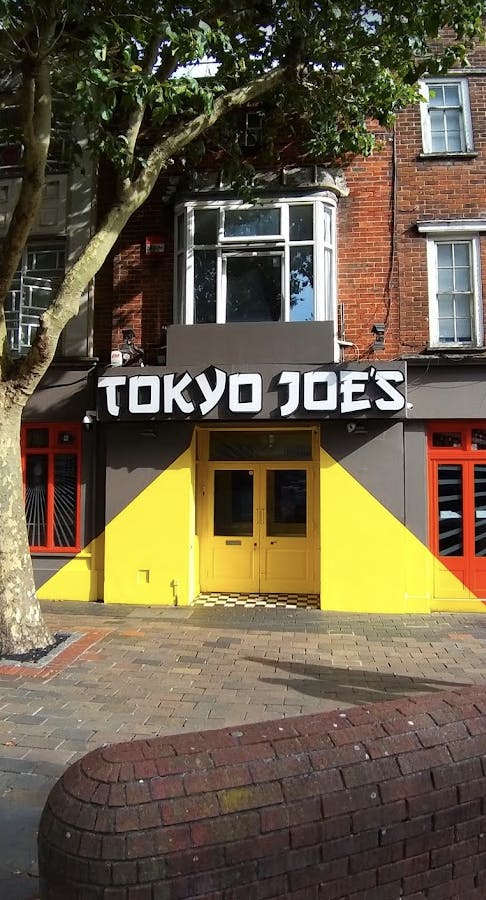 Vibrant Tokyo Joe's restaurant with yellow-gray exterior, perfect for events and gatherings.