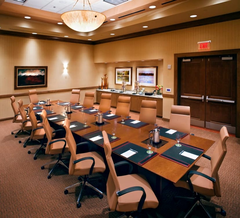 Conference room at Embassy Suites Loveland, featuring a polished table for meetings and events.