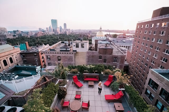 Rooftop venue at XV Beacon with red seating and city skyline, perfect for upscale events.