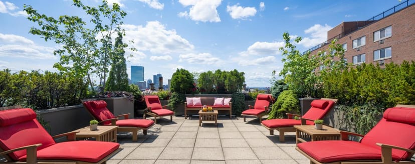 Stylish rooftop terrace at XV Beacon with red lounge chairs, ideal for events and networking.