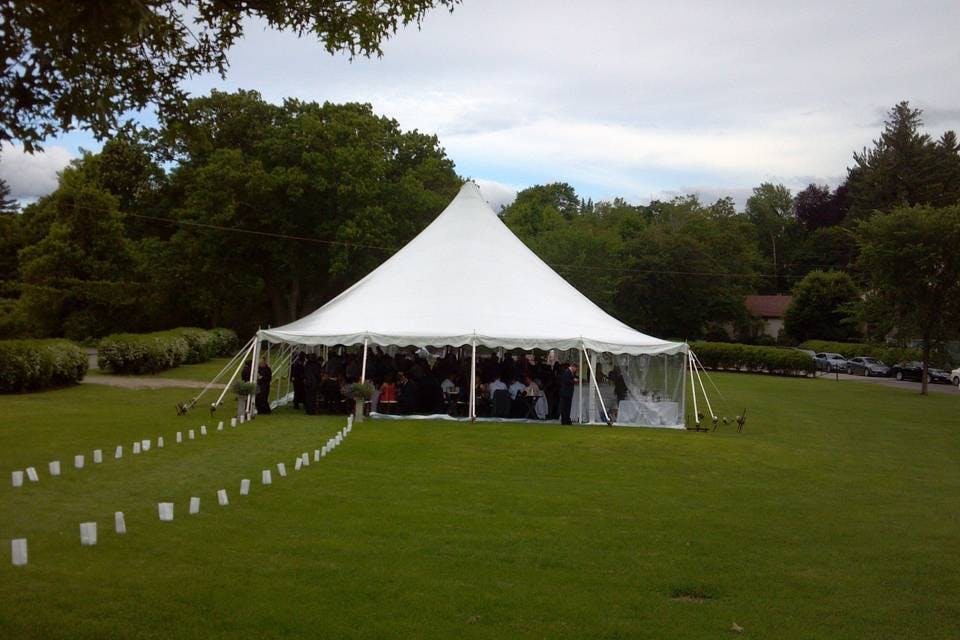 Outdoor wedding setup under a white tent at Larz Anderson Auto Museum, elegant ambiance.