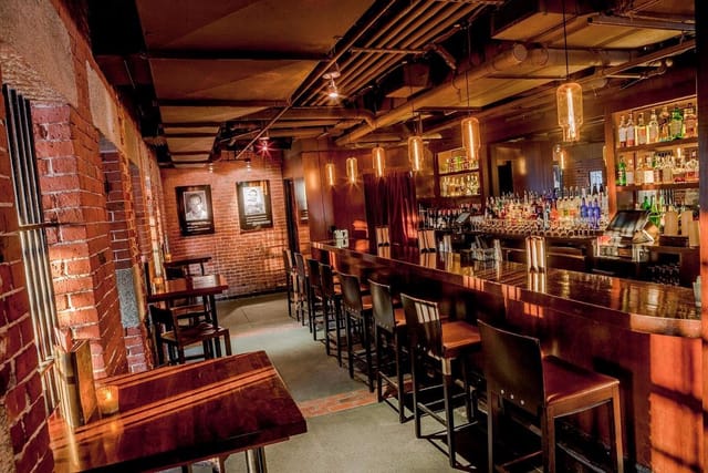 Indoor event space at Alibi Bar & Lounge with cozy lighting, ideal for gatherings and networking.