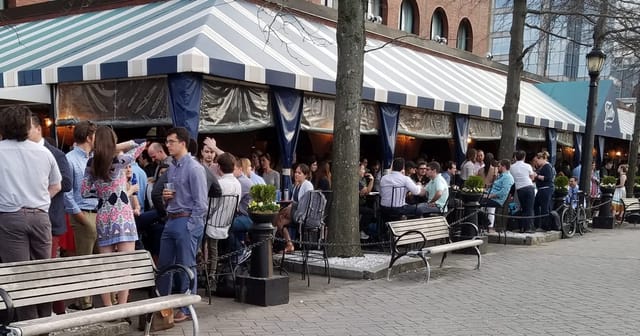 Waterfront patio in Tias with striped awning, perfect for networking events and receptions.