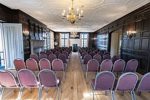 Elegant event space with burgundy chairs, ideal for corporate meetings and workshops.