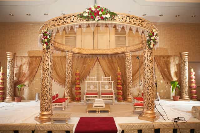 Elegant wedding stage with golden pillars and floral arrangements at Boston Marriott Burlington.