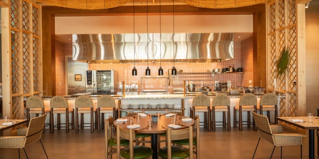 Modern banquet hall at Hotel Indigo, ideal for events with open kitchen and stylish seating.