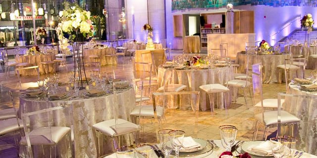Elegant event space with round tables and floral centerpieces in Boston Library.