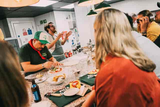 Pizza making workshop with chef demonstrating techniques for team-building events.