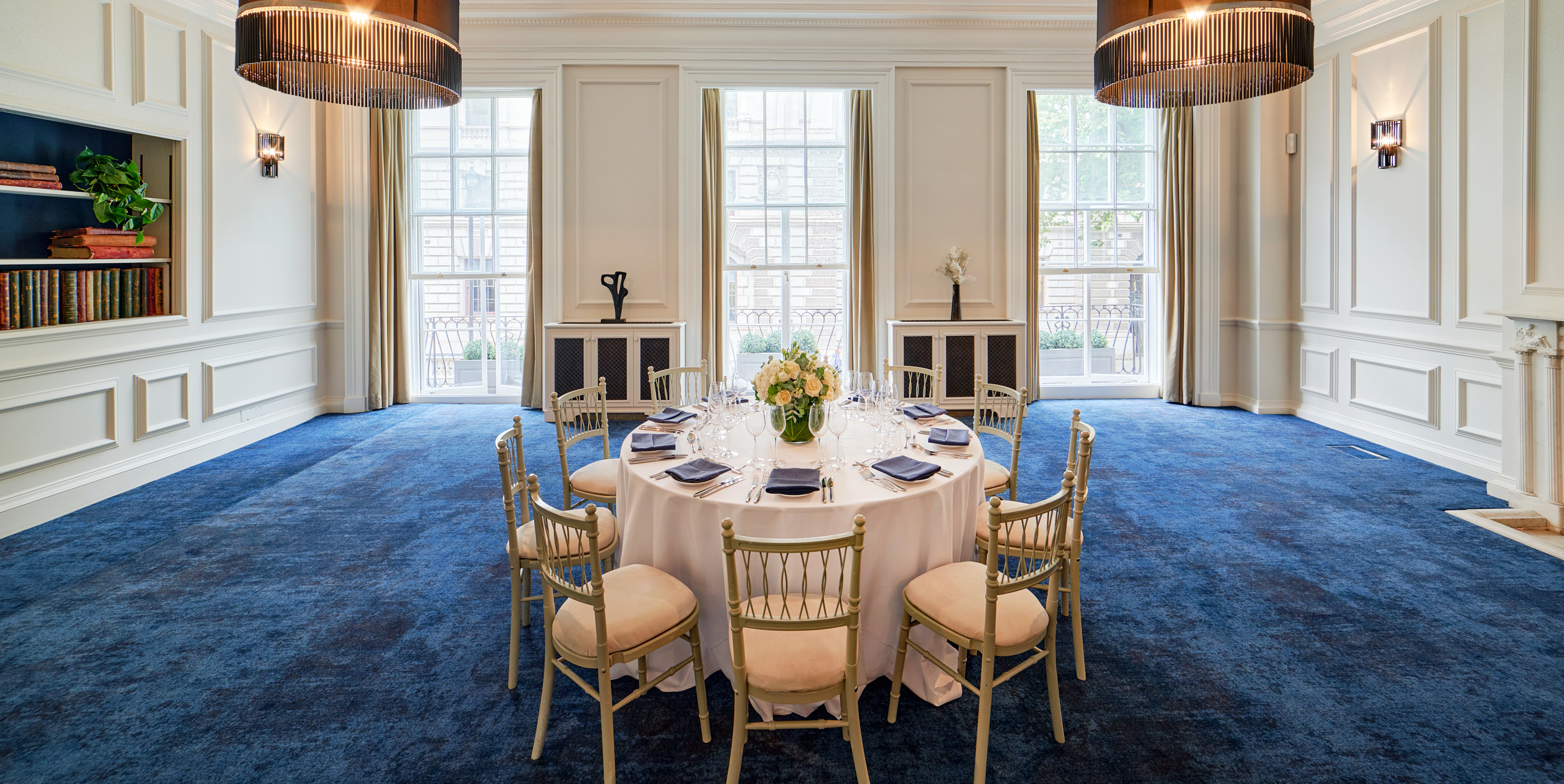 Elegant round table in well-lit event space for corporate meetings and private dinners. - Banner