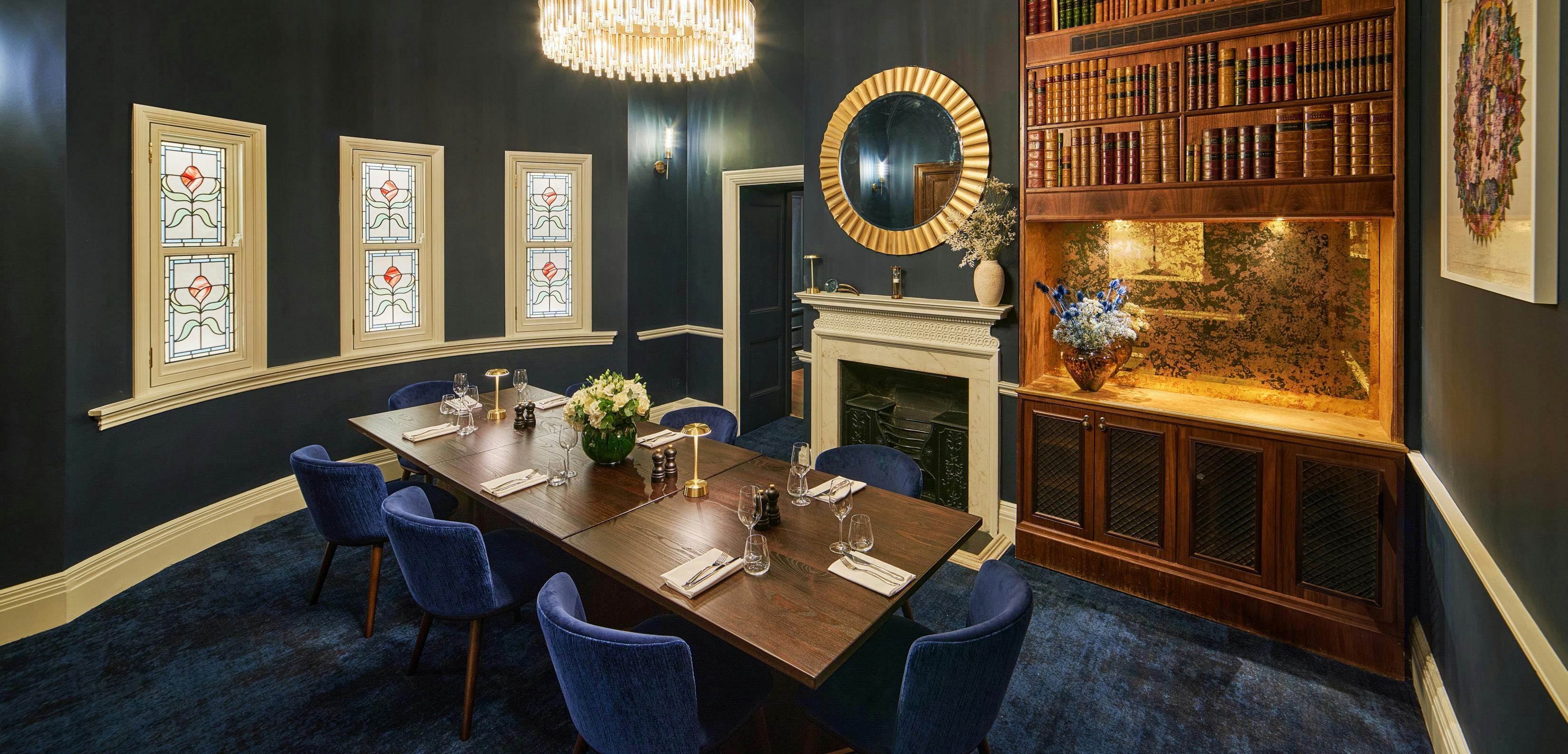 Elegant private dining room with blue walls, ideal for exclusive events and meetings.