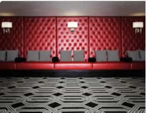 Madeleine in stylish Sofitel DC lounge with red tufted wall, perfect for networking events.