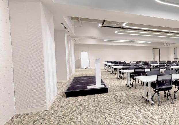 Versatile meeting space at The Forum, featuring an elevated podium for engaging presentations.