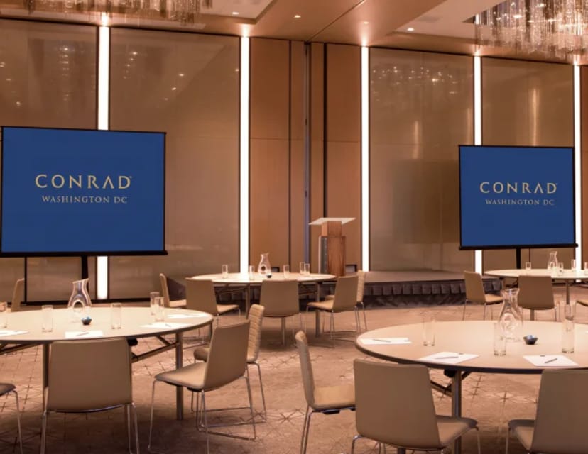 Corporate meeting room at Conrad Washington DC with modern decor and branding screens.