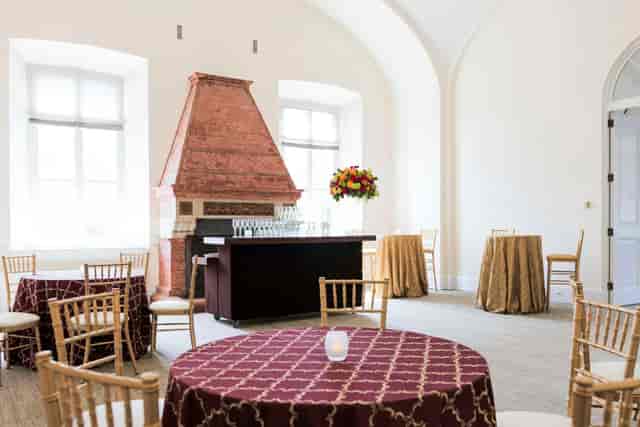 Elegant event space with round tables and gold chairs at National Building Museum.
