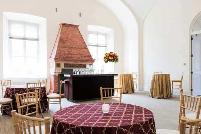 Elegant event space with round tables and gold chairs at National Building Museum.