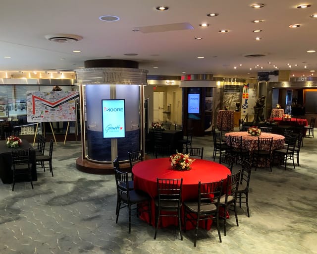 Arleigh & Roberta Burke Theatre with red and black tables for networking events.