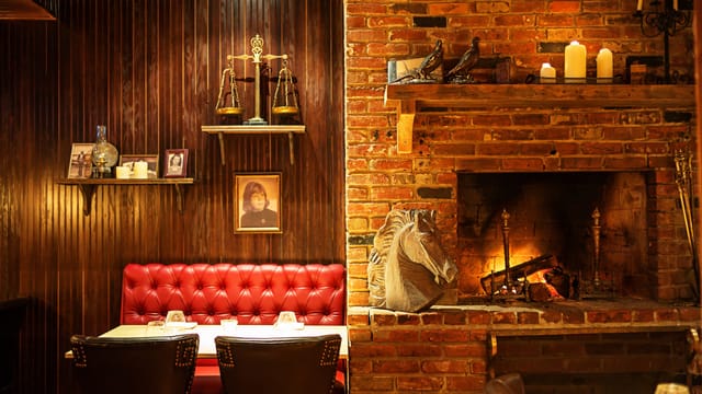 Cozy upscale indoor dining room with rich wood paneling, ideal for private events.