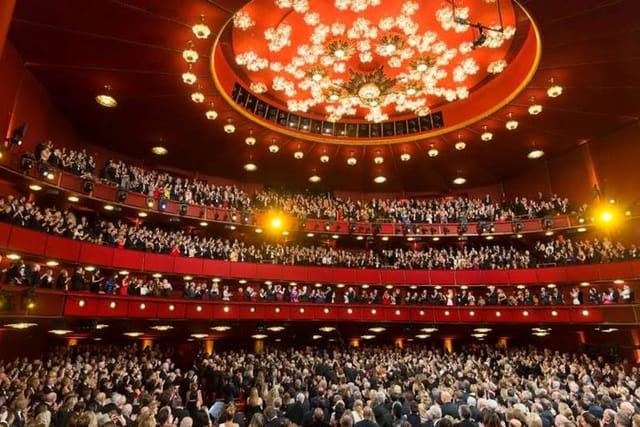 Packed Kennedy Center Concert Hall with dramatic lighting, ideal for performances and conferences.