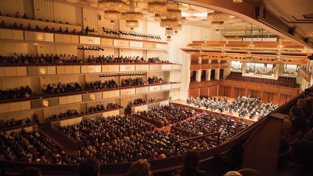Packed Kennedy Center concert hall with tiered seating for successful events.