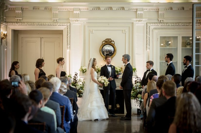 Elegant wedding ceremony at O'Byrne Gallery with floral decor and engaged guests.