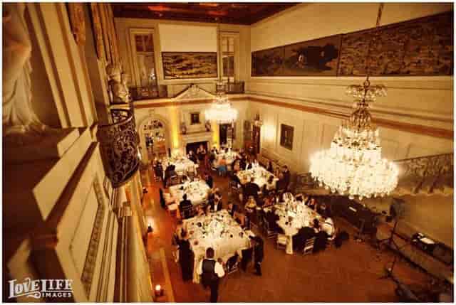 Elegant ballroom banquet setup under chandelier for weddings and high-profile events.