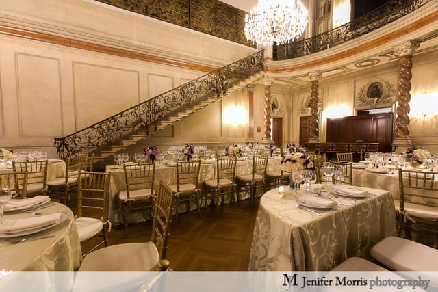 Elegant ballroom with grand staircase, perfect for sophisticated dinners and galas.