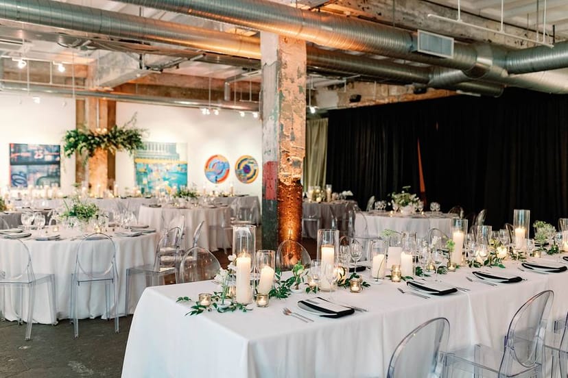 Elegant art gallery event space with round tables and floral arrangements in Long View Gallery.