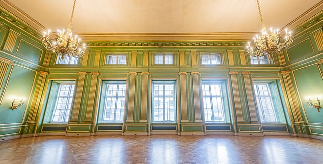 Elegant Green & Gold Room with high ceilings, perfect for upscale events and meetings.