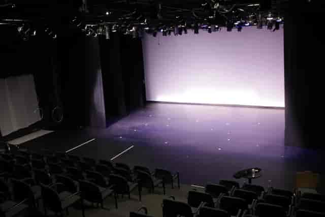 Versatile event space with spacious stage and tiered seating at Atlas Performing Arts Center.