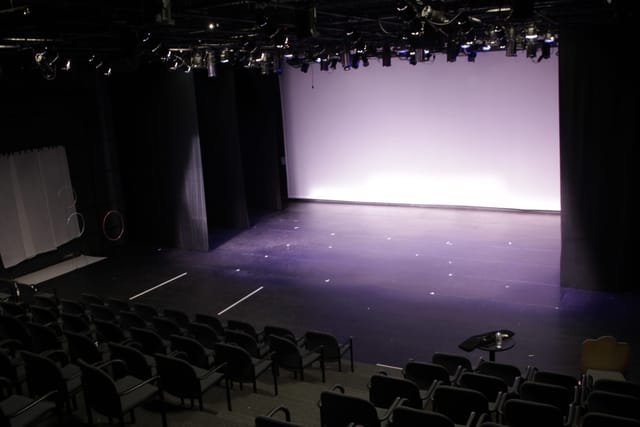 Versatile event space with spacious stage and tiered seating at Atlas Performing Arts Center.
