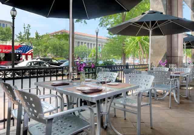 Outdoor dining area at JW Marriott DC, featuring sleek metal furniture for networking events.