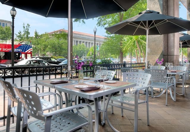 Outdoor dining area at JW Marriott DC, featuring sleek metal furniture for networking events.