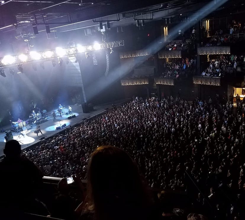 Packed concert hall with vibrant audience enjoying a live performance event.
