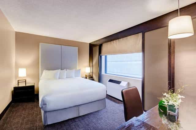 Modern hotel suite in Ottawa with a comfortable bed, perfect for event attendees.