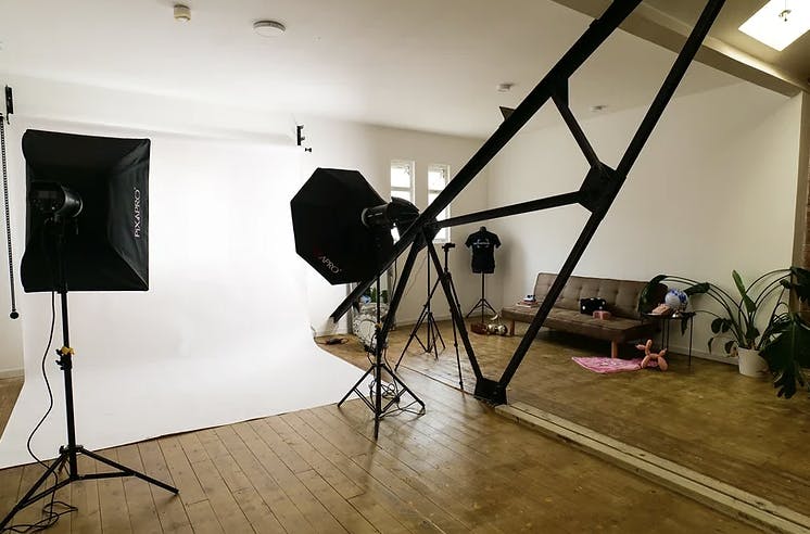 Photography studio with white backdrop, ideal for professional photo shoots and events.