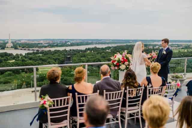 Rooftop wedding ceremony at Top of the Town with city skyline view and floral decor.