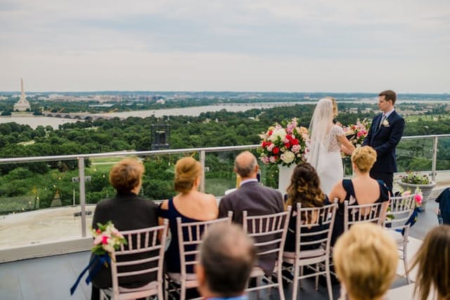 Rooftop wedding ceremony at Top of the Town with city skyline view and floral decor.