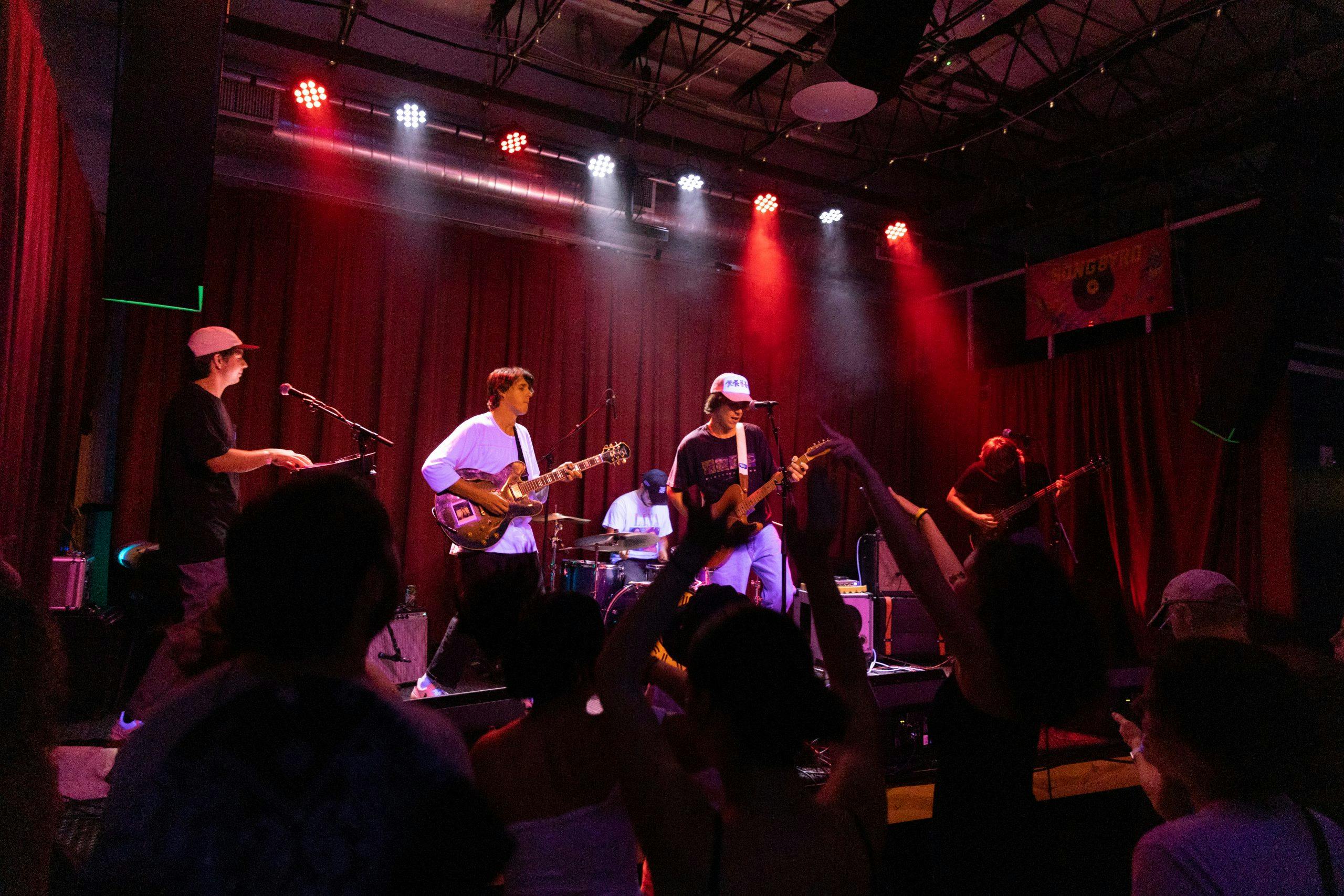 Live music performance at Songbyrd Music House with vibrant lighting and engaged audience.