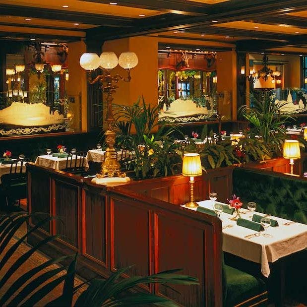 Elegant fine dining restaurant with lush greenery, ideal for upscale events and gatherings.