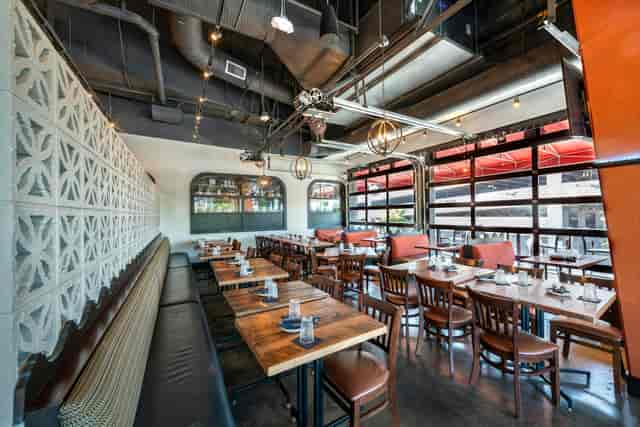 Modern dining room with wooden tables, ideal for intimate meetings and casual dining events.